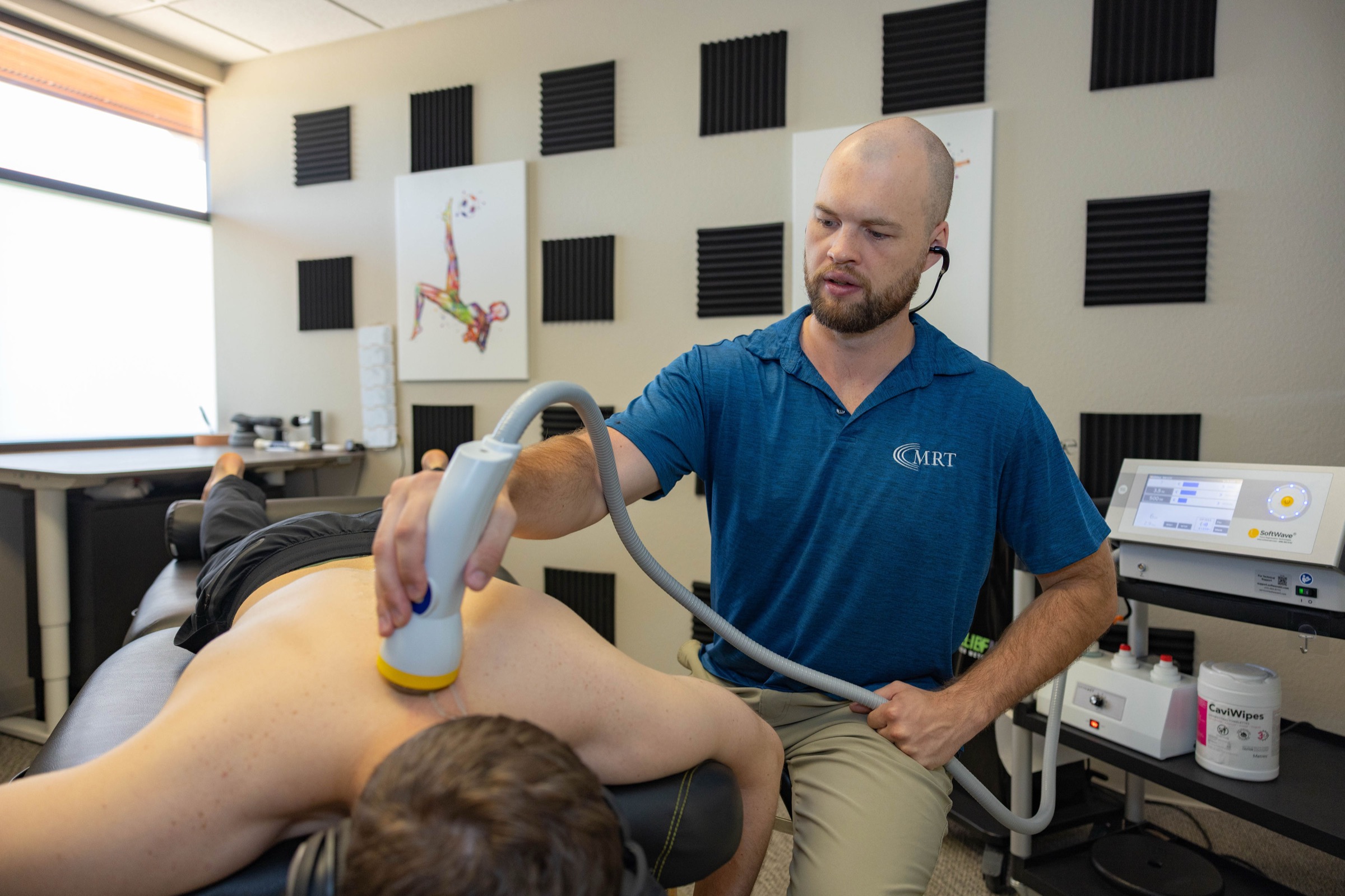 SoftWave applicator on a client's upper back and shoulder at Muscle Restoration Therapy, Fort Collins.