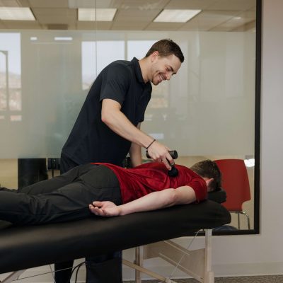 Practitioner checking muscle function during an appointment in Fort Collins